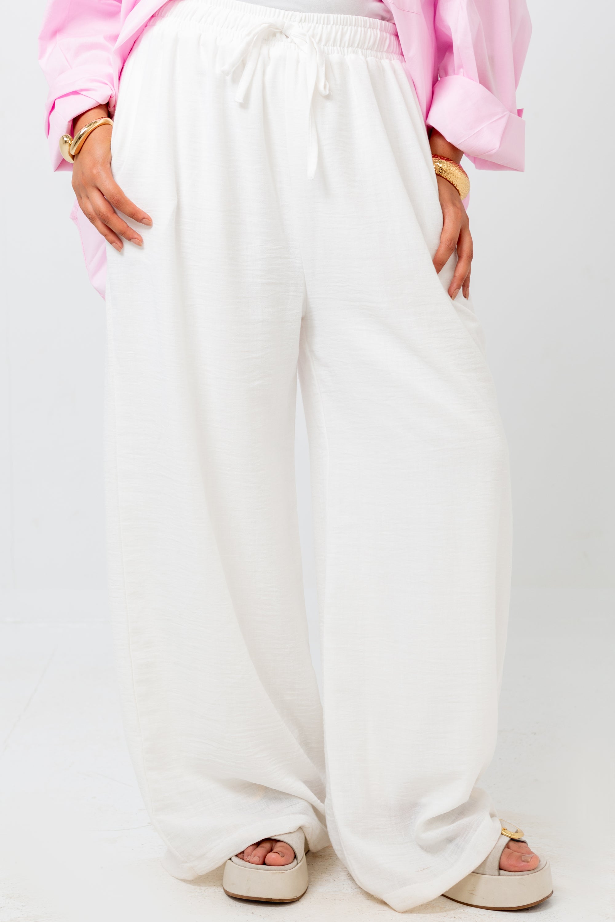 White wide-leg pants worn by a person on a white background