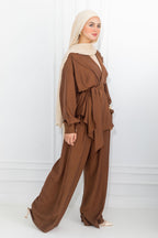 Woman wearing a brown outfit with a beige hijab on a white background