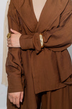 Brown outfit with a belt and gold buckle on a plain background