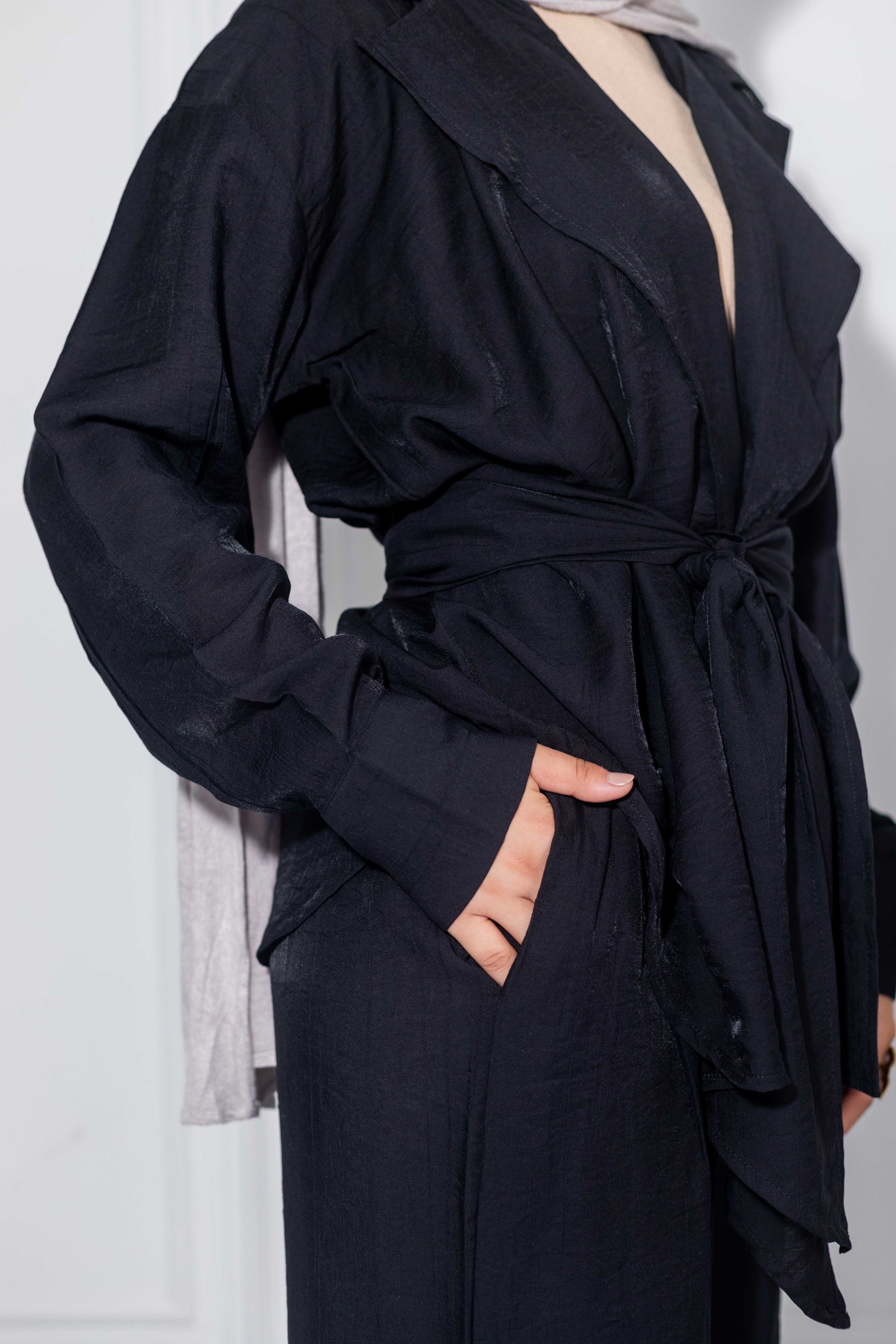 Black wrap dress with a belt on a white background