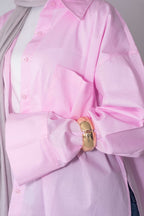 Pink shirt with a large bow and gold buckle detail