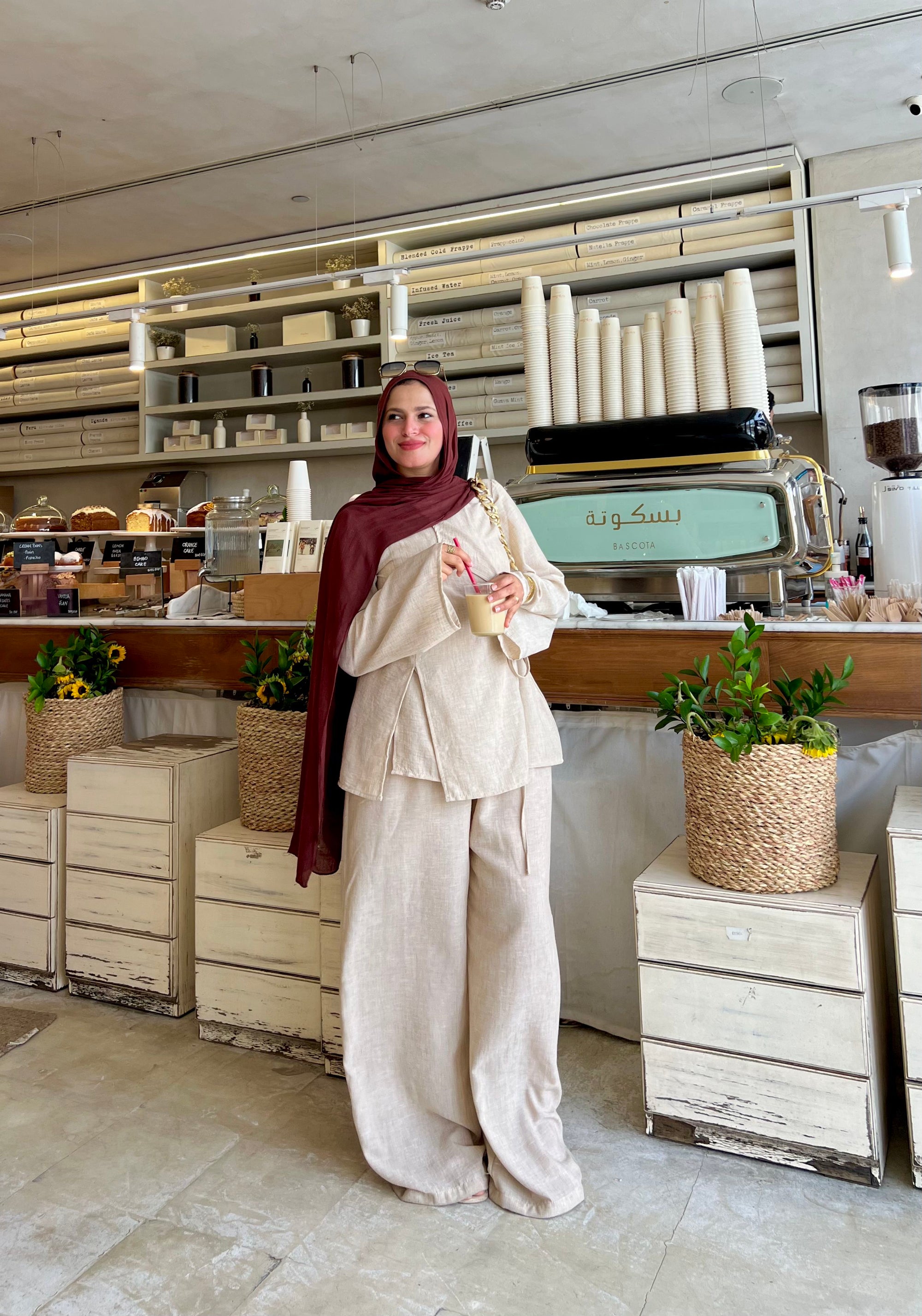Person in a beige outfit standing in a modern kitchen or bakery.