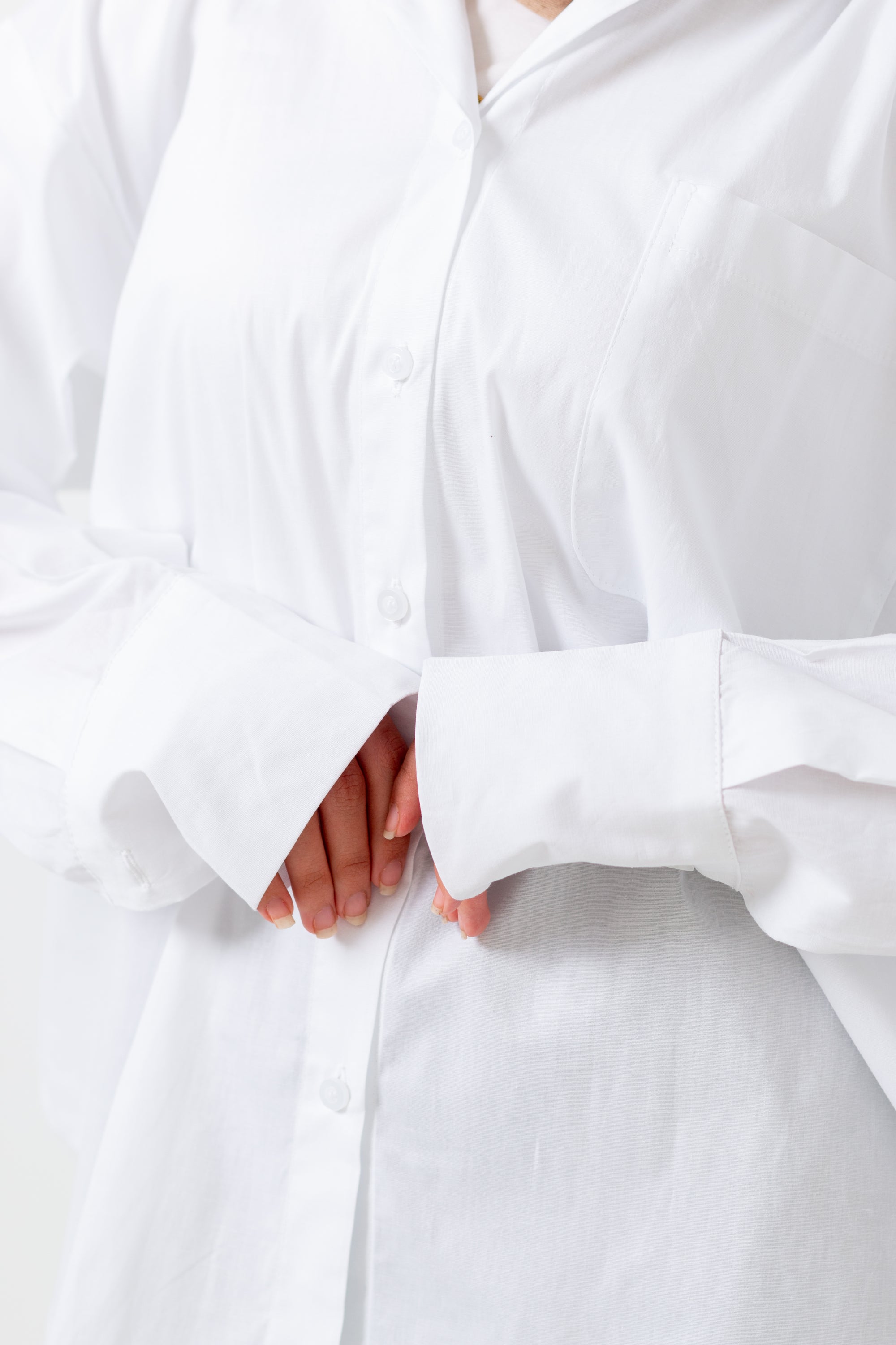 Close-up of a white outfit with a bow detail on a plain background