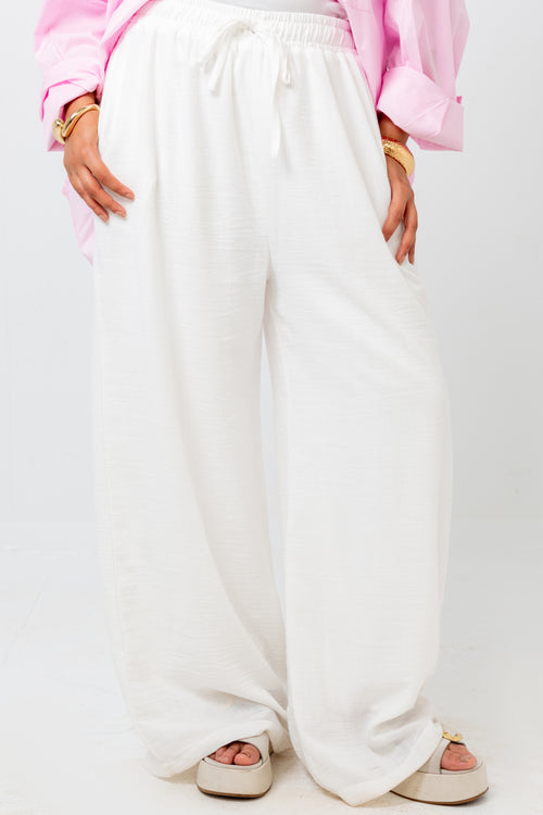 White wide-leg pants worn by a person on a white background
