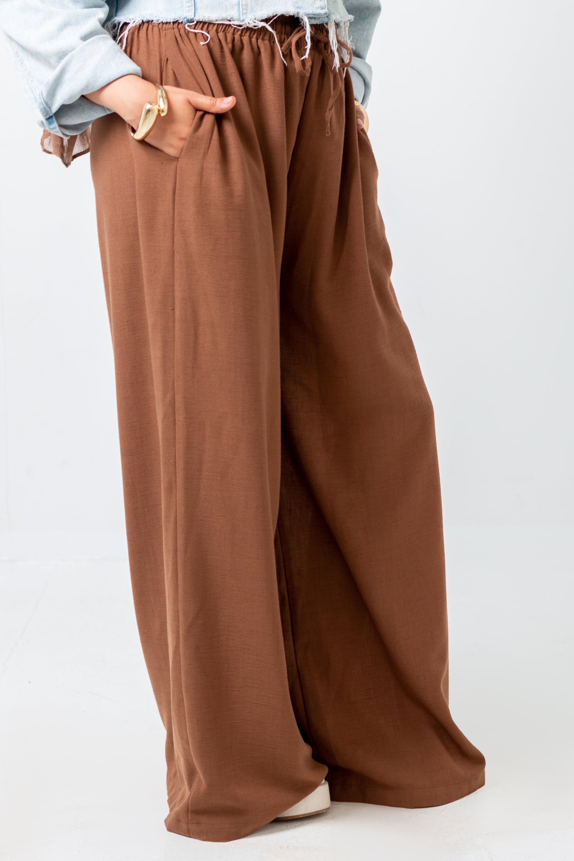 Brown wide-leg pants worn by a person on a white background
