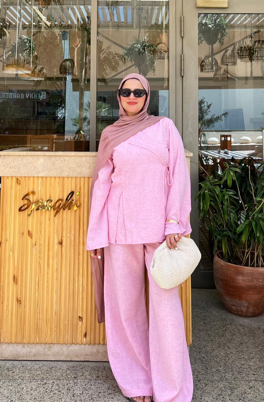 Woman in a pink outfit standing outside a restaurant with 'Spaghet' visible on the door.