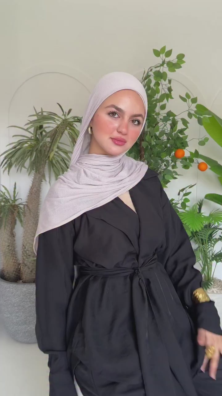 A woman wearing a modest outfit and hijab, showcasing elegant modern Islamic fashion.