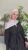 A woman wearing a modest outfit and hijab, showcasing elegant modern Islamic fashion.